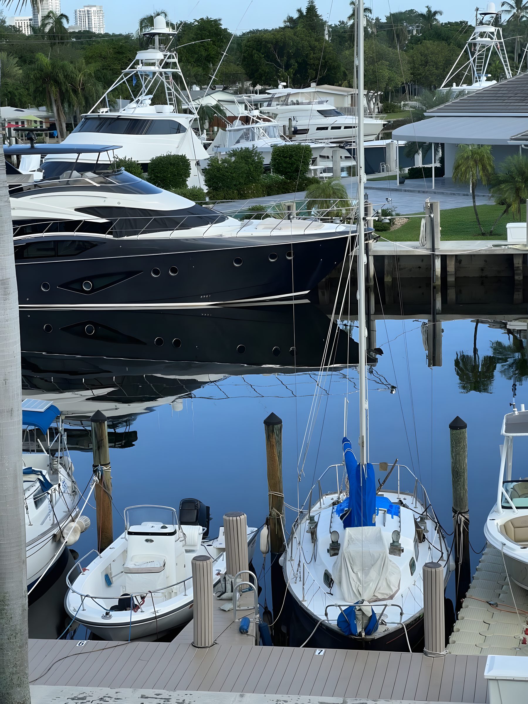 The association's boat slips at dusk, sailboats and a motor yacht reflected in still water.